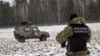 POLAND/BELARUS - A Polish border guard officer stands near a military car with a sound system emitting warnings in five languages to inform migrants that crossing the border is illegal, 25JAN2022