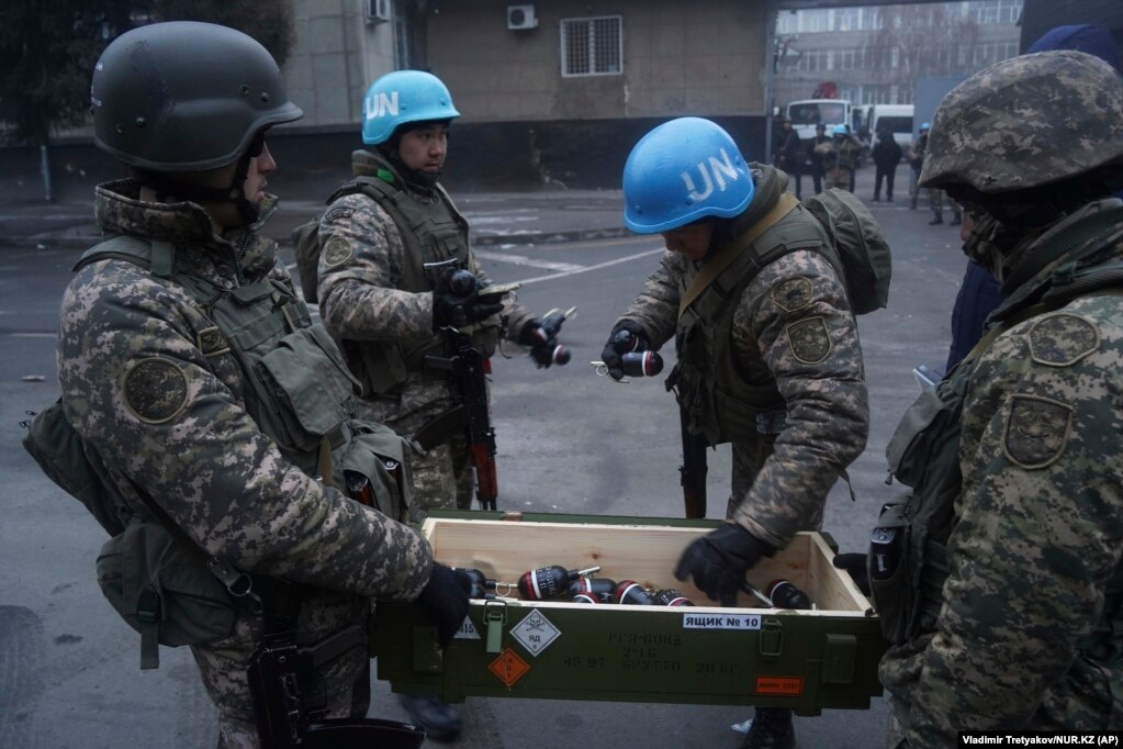 Kazakh soldiers wearing blue "UN" helmets pick out flash-bang grenades in Almaty on January 6. Arm badges on the servicemen are those of the Kazakh military.