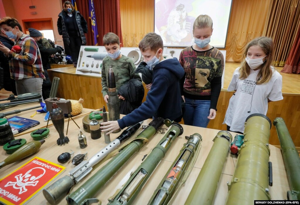 Disa nxënës në Ukrainë duke shikuar municione gjatë një ore mësimi në Kiev, më 27 janar, ku ata u këshilluan se si t'i dallojnë dhe si t'i trajtojnë pajisjet dhe armatimin e dyshimtë, teksa tensionet ushtarake janë rritur në kufirin lindor të vendit të tyre.