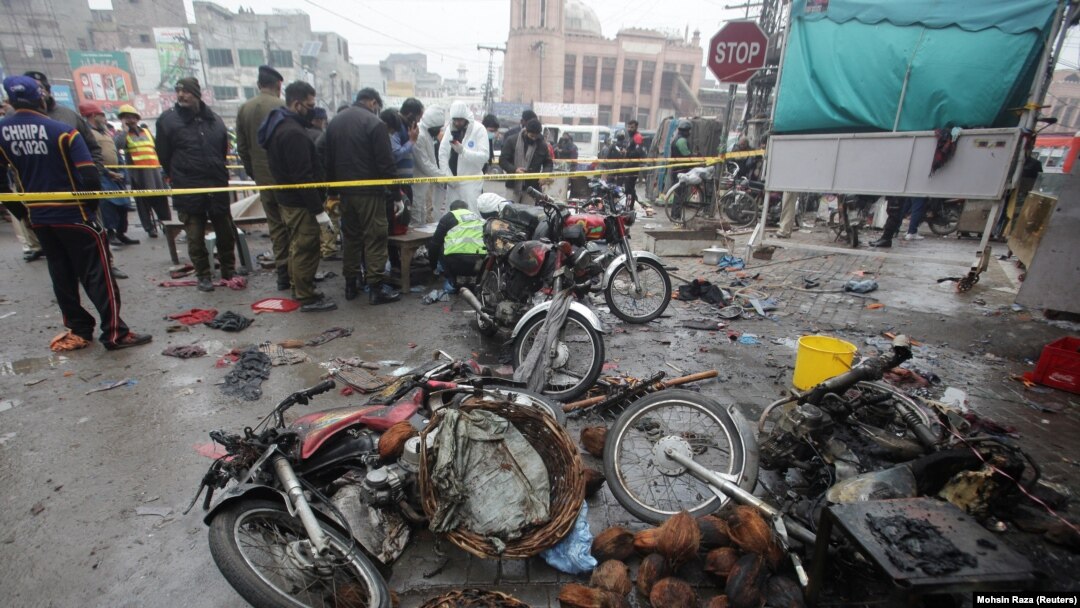 Members of a crime scene unit and a bomb disposal team gather after a blast at a market in Lahore on January 20.