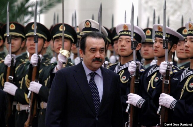 Kazakhstan's then-prime minister, Karim Masimov, inspects an honor guard during an official welcoming ceremony in the Great Hall of the People in Beijing in 2002.