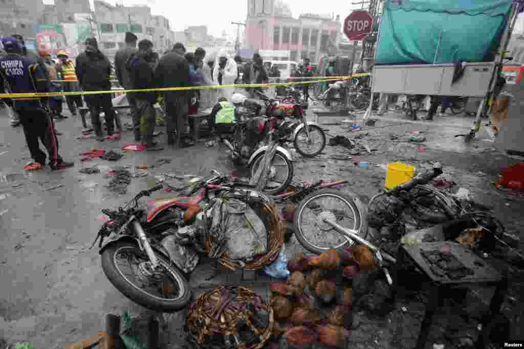 Pakistani security officers inspect the aftermath of a bomb blast at a market in Lahore on January 20.