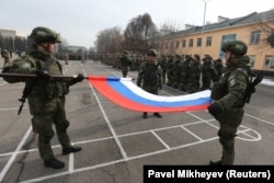 Russian soldiers fold their national flag during a ceremony marking the beginning of the withdrawal of CSTO peacekeeping troops from Kazakhstan on January 13.