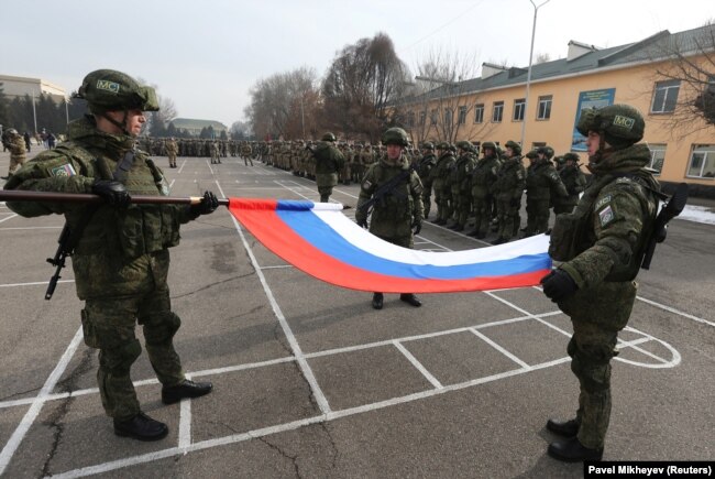 Russian soldiers fold their national flag during a ceremony marking the beginning of the withdrawal of CSTO peacekeeping troops from Kazakhstan on January 13.