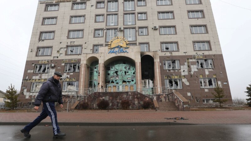 Прохожий на фоне разгромленного во время протестов и беспорядков здания, где размещался районный филиал партии «Нур Отан». Алматы, 8 января 2022 года 