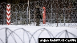 Katona a szögesdróttal megerősített lengyel–belarusz határon 2022. január 25-én