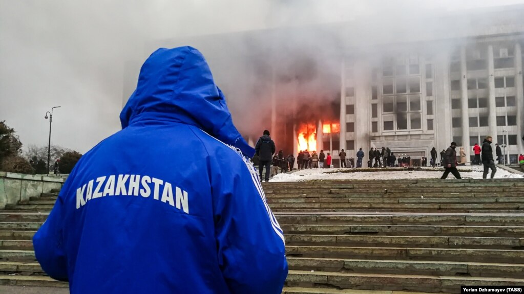Протестующие возле горящего здания акимата. Участники протеста против роста цен на топливо ворвались в здание акимата и подожгли его. Алматы, 5 января 2022 года
