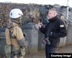 Fotojurnalistul st Andriy Dubchak in timp ce intervievează un soldat.