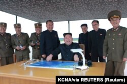کیم جونگ اون در این عکس که خبرگزاری حکومت کره شمالی در آگوست ۲۰۱۷ منتشر کرد، مانور پرتاب موشک بالیستیک دوربرد و متوسط را بازرسی می‌کند