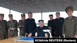 Lideri verikorean, Kim Jong-un duke shikuar testimin e një rakete bashkë me ekipin e tij. Fotografi nga arkivi.