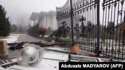 Разрушенный забор возле административного здания в центре Алматы после вспыхнувших протестов против повышения цен на топливо, 7 января 2022 года