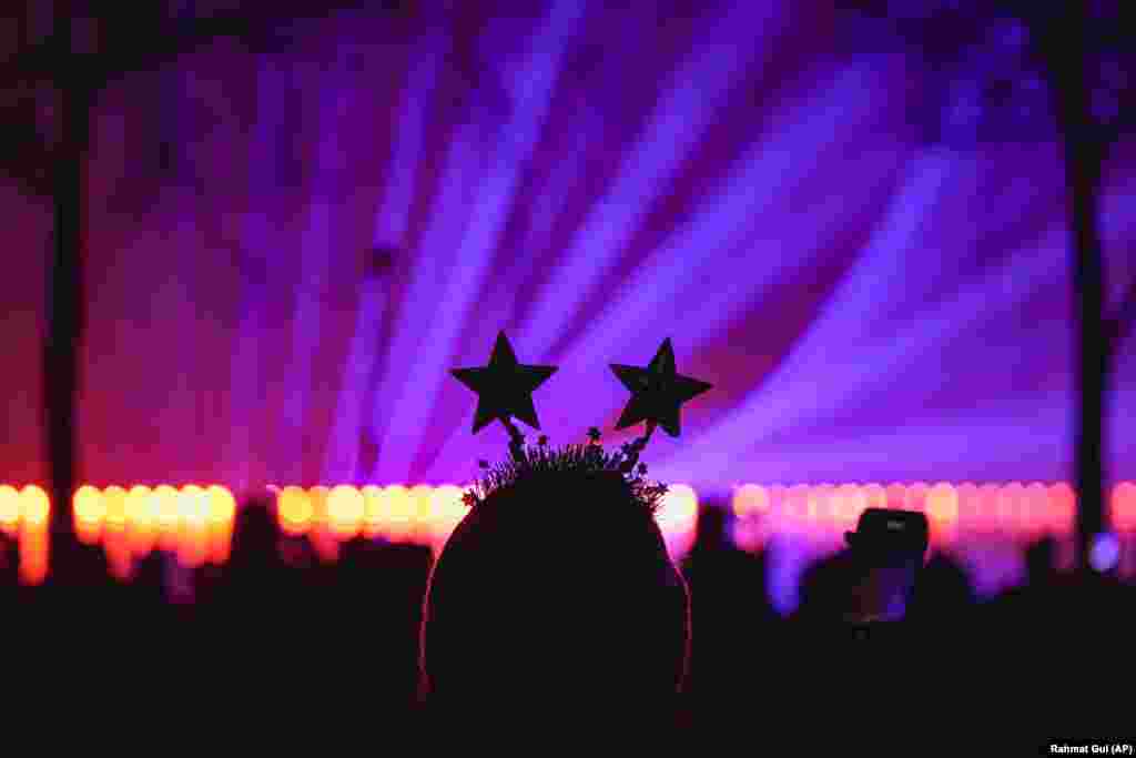 A woman watches a laser show during New Year&#39;s celebrations in Bucharest.