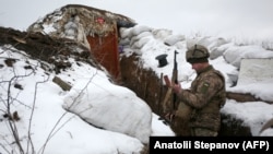 A Ukrainian soldier checks his weapon as he stands in a trench on the front line with Russia-backed separatists near the village of Zolote in the eastern Luhansk region on January 21. 