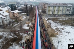 Serbët e Bosnjës duke mbajtur një flamur gjigant serb teksa marshonin në Sarajevë më 9 janar.