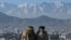 Members of the Taliban sit overlooking the Kabul city at the Wazir Akbar Khan hill in Kabul on January 20, 2022. 22potw03