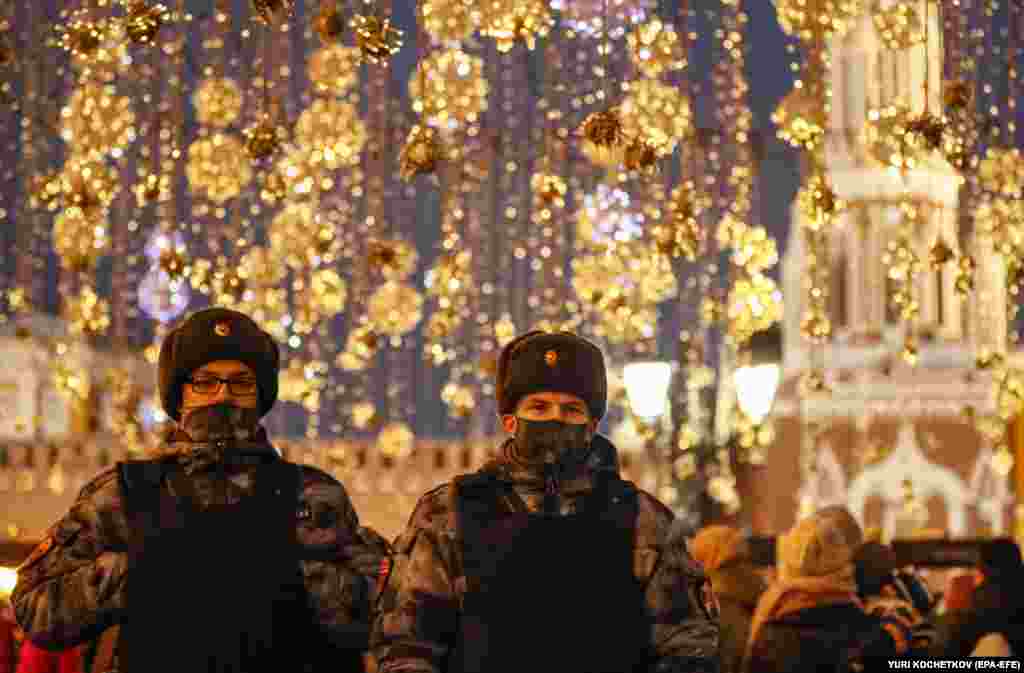 Police officers walk on a street decorated for the upcoming Christmas celebrations amid the COVID-19 pandemic in Moscow.