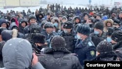 Policajci razgovaraju s demonstrantima koji zbog cene goriva protestuju u gradu Oral na zapadu Kazahstana, 4. januar