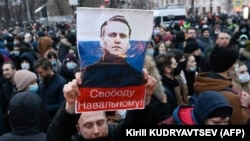 Supporters hold up a poster of jailed Russian opposition politician Aleksei Navalny, who said Russia's war with Ukraine will "destroy futures."