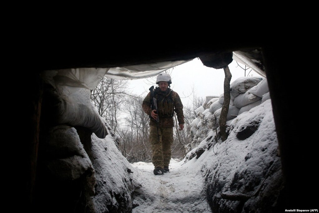 Një luftëtar ukrainas duke ecur nëpër një llogore, në rajonin e Luhanskut, më 22 janar.