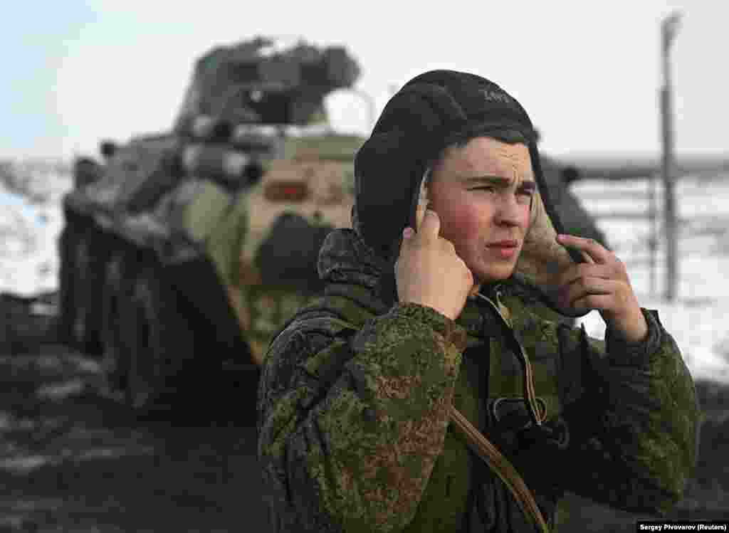 Një anëtar i ekuipazhit të një automjeti ushtarak rus duke vendosur kapelën gjatë stërvitjeve në poligonin Kuzminsky, më 26 janar.