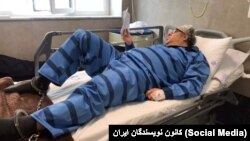 Jailed Iranian poet Baktash Abtin is pictured after being hospitalized in July 2021.