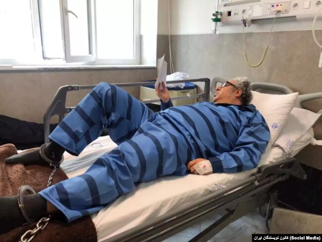 Baktash Abtin is shown shackled to his hospital bed in July 2021.