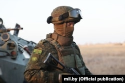 A Belarusian peacekeeping soldier near an armored vehicle in Kazakhstan. A badge on his right arm has sparked claims that Belarus is engaged in "trolling" the UN.