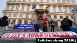 Акція біля посольства Німеччини у Чехії, Прага, 27 січня 2022 року. Активісти принесли під посольство опудало «голого Путіна» та залізну трубу з написом «Північний потік-2» і розгромили її кувалдою