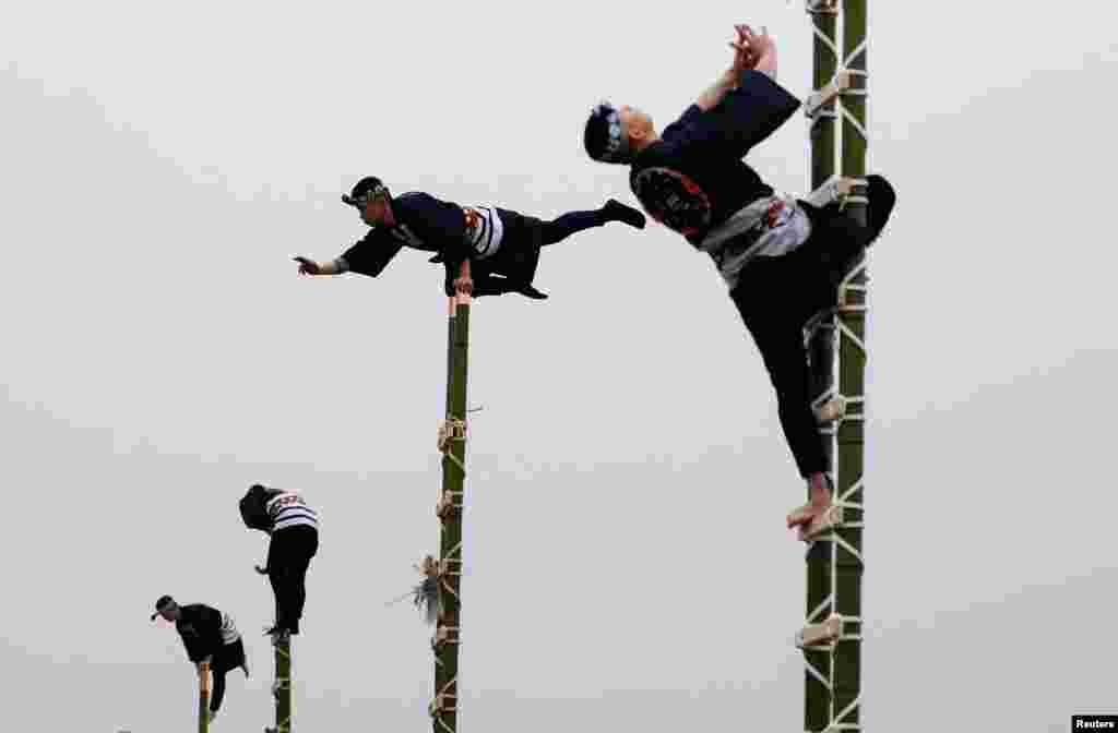 Members of the Edo Firemanship Preservation Association display their balancing skills atop bamboo ladders during a New Year demonstration by the fire brigade in Tokyo, Japan, January 6, 2022