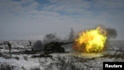 A Russian soldier fires a howitzer during drills at the Kuzminsky range in the southern Rostov region on January 26.