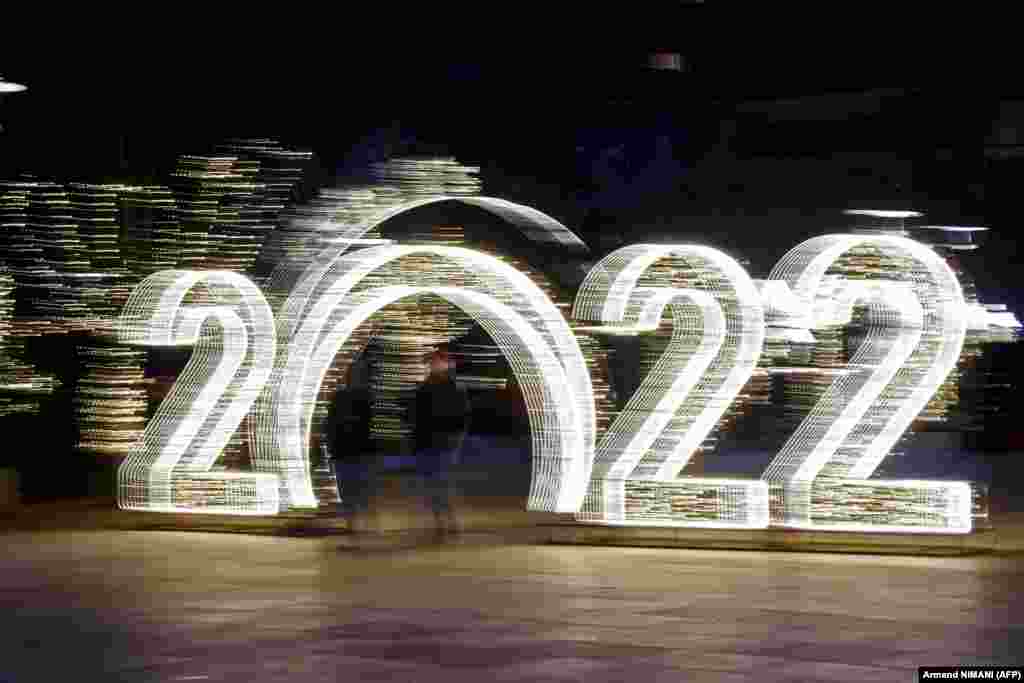 Pedestrians walk in front of a 2022 sign in downtown Pristina on December 30, ahead of the New Year celebrations in Kosovo.