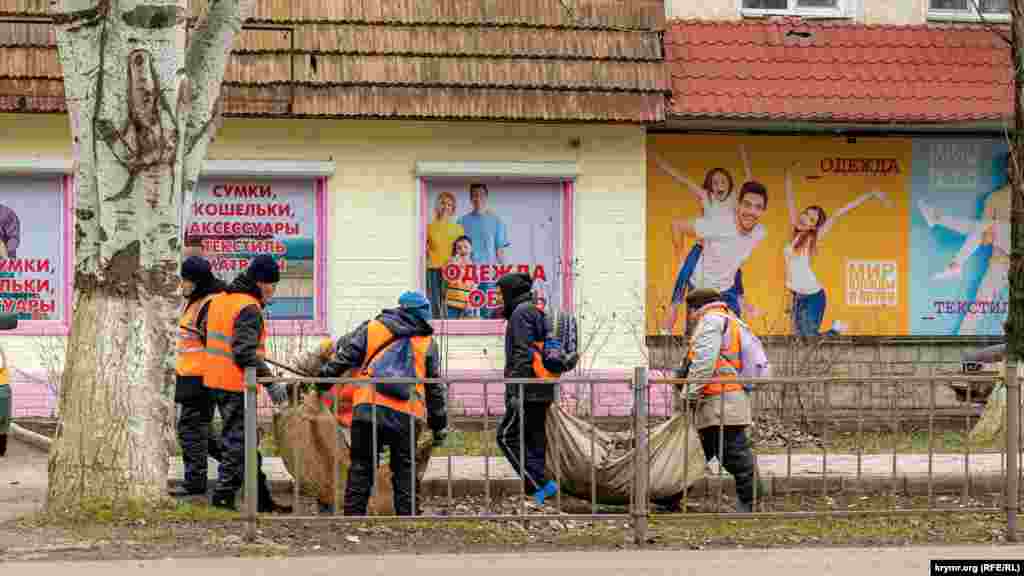 Коммунальщики убирают прошлогоднюю листву на улице Генерала Захарова