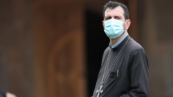 Armenia -- A priest wears a face mask at the Echmiadzin-based Mother See of the Armenian Apostolic Church, June 11, 2020.