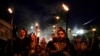 People in folk costumes hold torches during a procession the night before the wedding in the village of Galicnik.