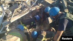 Rescuers work in the ruins of a residential building destroyed by a military strike in the town of Toretsk in Ukraine's Donetsk region. 