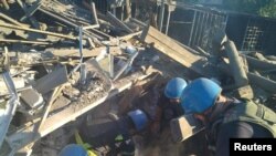 Mentők szabadítanak ki egy férfit egy orosz katonai csapásban lerombolt lakóépület romjai közül az ukrajnai Toretszk városában 2022. július 18-án