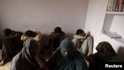 Children whose families say have been abused, hide their faces while their mothers are interviewed by a Reuters correspondent in their village of Husain Khan Wala on August 9.