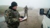 Український прикордонник перевіряє документи на пункті пропуску в Бердянську, 27 листопада 2018 року 