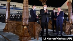 China's Xi Jinping is welcomed by Uzbek President Shavkat Mirziyoev (right) at an airport in Samarkand on September 14, 2022.