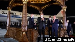 Xi Jinping is welcomed by Uzbek President Shavkat Mirziyoyev (right) at an airport in Samarkand on September 14.