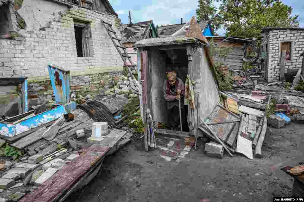 Опкружена со уништени домови, Нина Хончар излегува од својата визба во селото Бохородихне, 25 километри југоисточно од Изум.