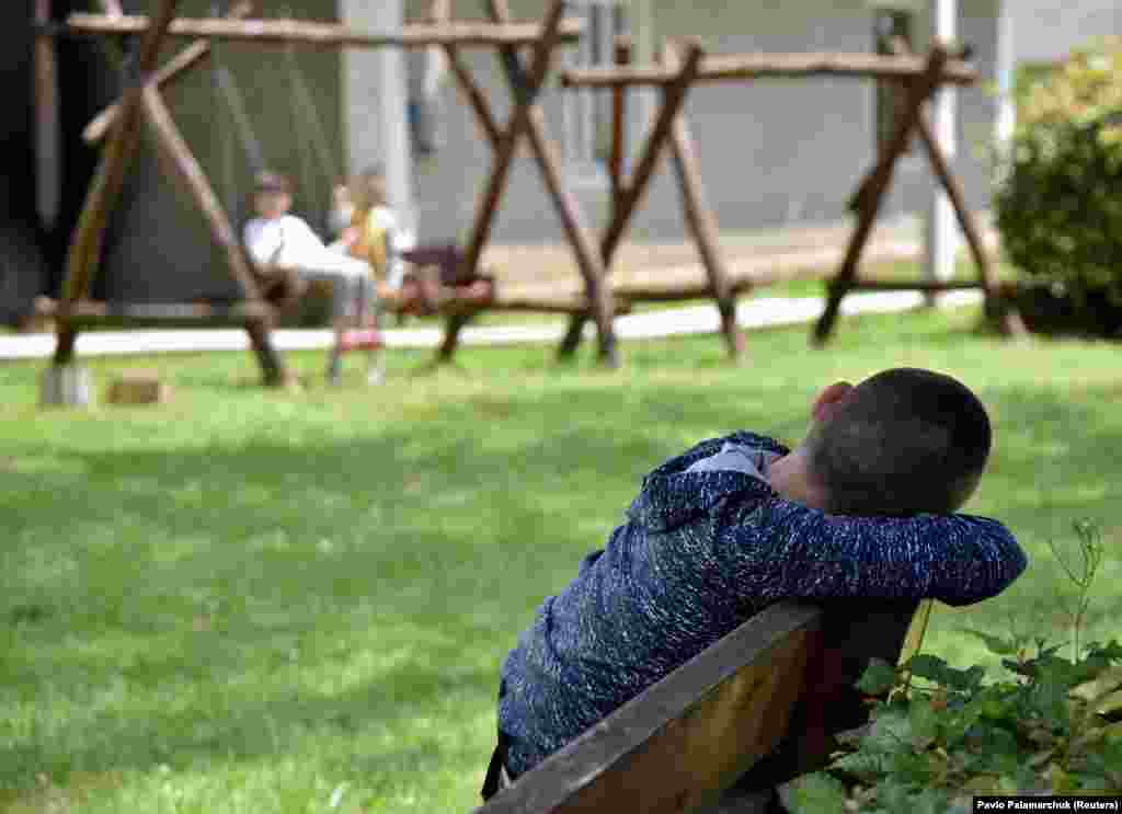 Egy gyermek nézi, ahogy egy másik fiú hintázik a Lelechenya (Kis gólya) rehabilitációs központban az ukrajnai Dzsurivban, ahová Odesszából szállították őket a háború miatt. Az UNICEF szerint még mindig több mint húszezer olyan gyermeket keresnek, akik&nbsp;&ndash; ahelyett hogy a gyermekvédelmi rendszeren belül szállítottak volna el &ndash; a háború kitörése után visszakerültek a családjukhoz vagy a törvényes gyámjukhoz