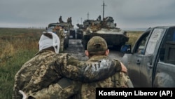 Ukrajinski vojnik pomaže ranjenom kolegi na putu na oslobođenoj teritoriji u oblasti Harkiva, Ukrajina, ponedeljak, 12. septembra 2022.