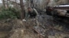 A military sapper picks up unexploded parts of a cluster bomb in the Kyiv region, Ukraine, on April 10, 2022.