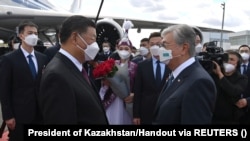 Kazakh President Qasym-Zhomart Toqaev (left) greets his Chinese counterpart, Xi Jinping, upon the latter's arrival in Nur-Sultan on September 14. 