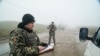 Украинский пограничник проверяет документы на пункте пропуска в Бердянске, 27 ноября 2018