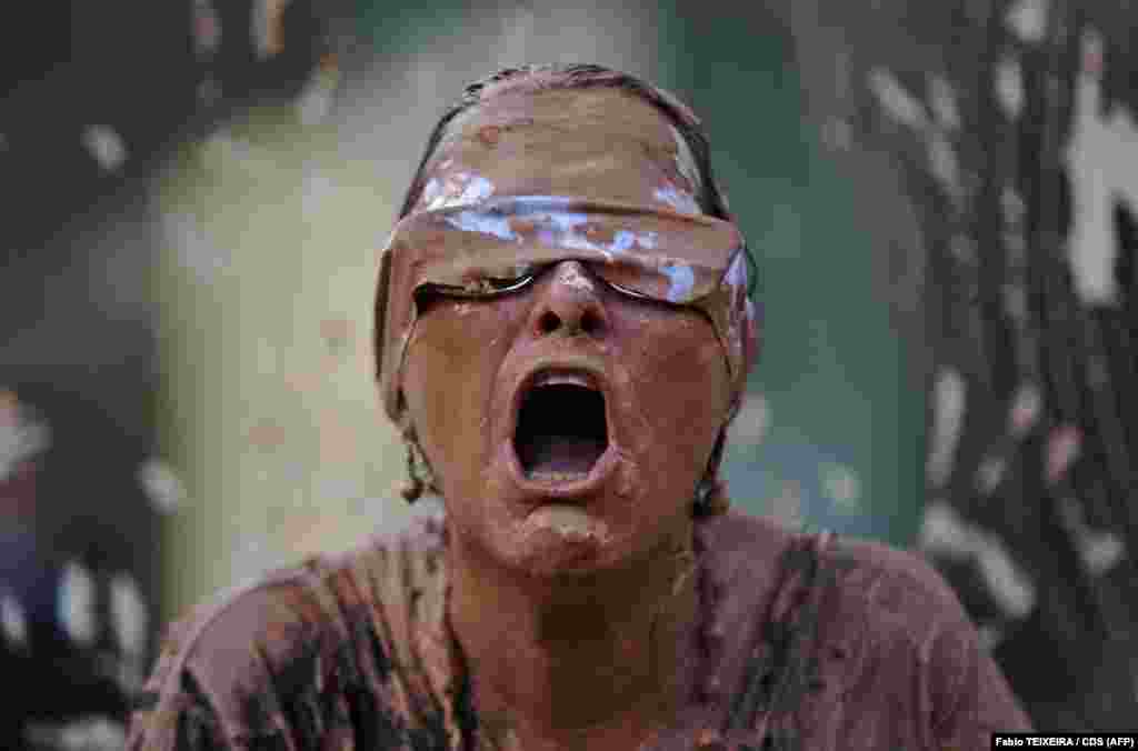 A protester covered in mud performs during a demonstration in front of the headquarters of Brazilian mining company Vale in Rio de Janeiro. A tsunami of mineral-laced mud broke through a dam at an iron-ore mine owned by Vale near the town of Brumadinho on January 25, killing 99 with another 250 missing. (AFP/Fabio Teixeira)