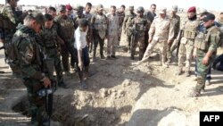 Iraqi forces search the site of a suspected mass grave containing the remains of victims of the Islamic State group last month, southwest of Hawija.