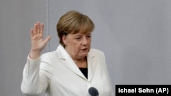 Angela Merkel, depunând jurământul