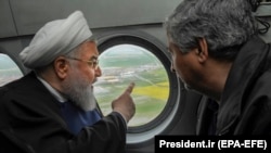 Iranian President Hassan Rohani (L) is seen in a helicopter inspecting the flood-affected villages in Golestan province, March 27, 2019